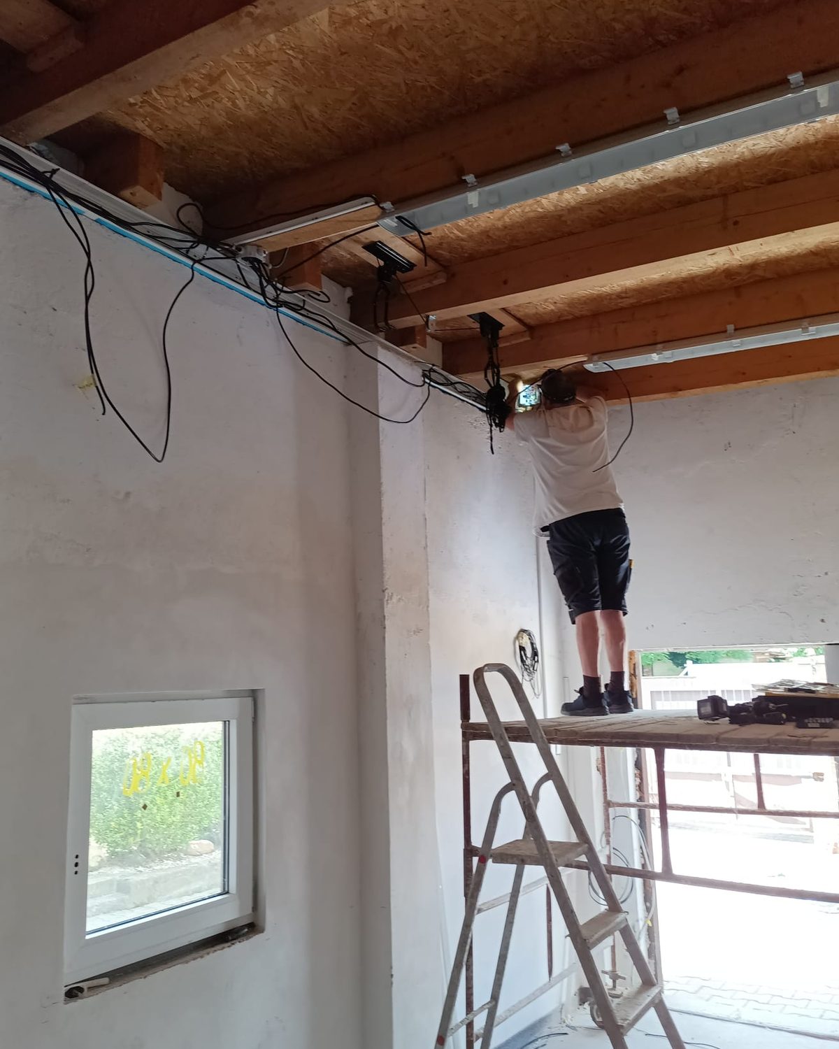 Vedení nové elektroinstalace pod stropními trámy dřevostavby